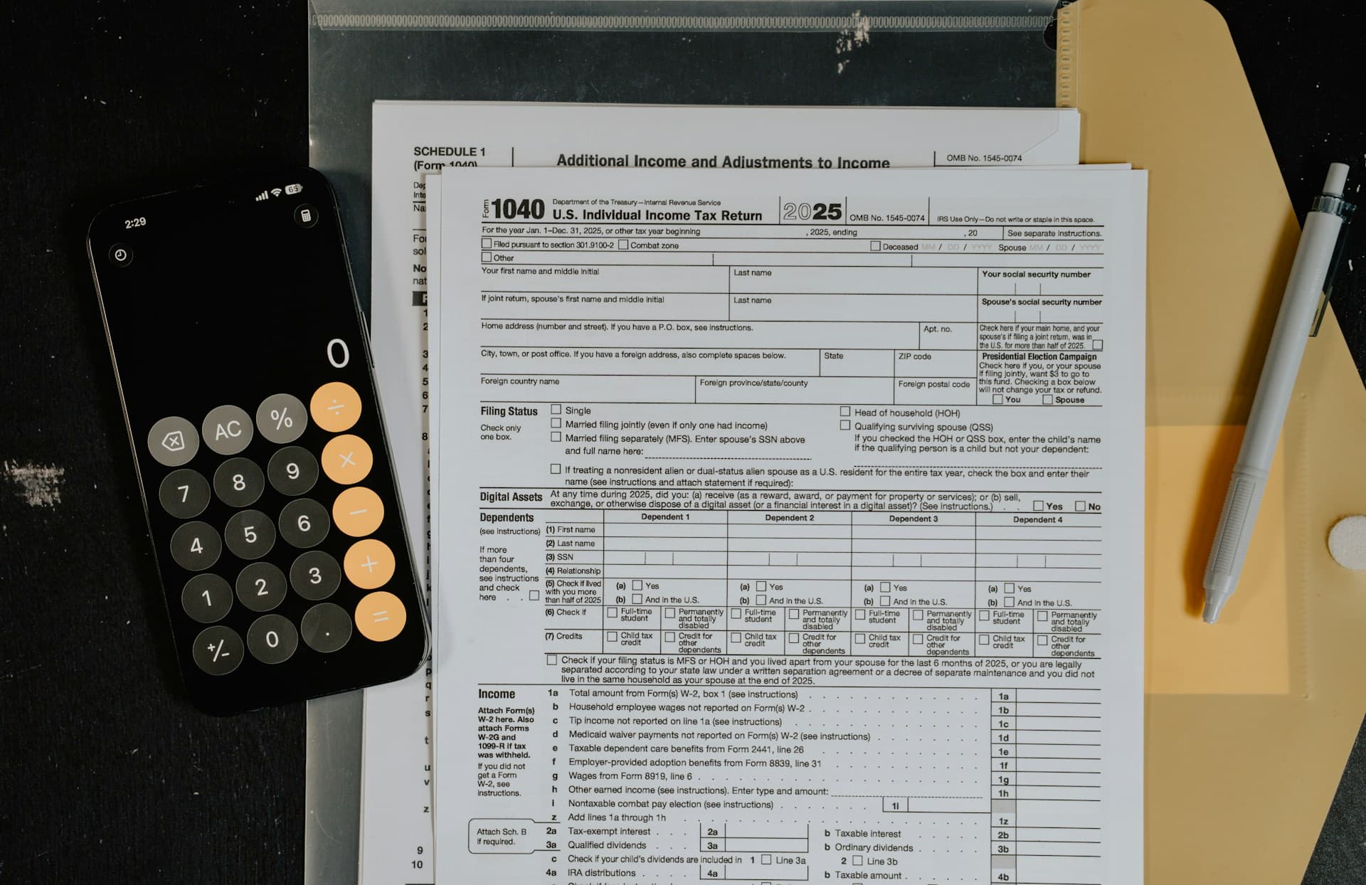Tax forms, calculator, pen, and financial paperwork on a desk